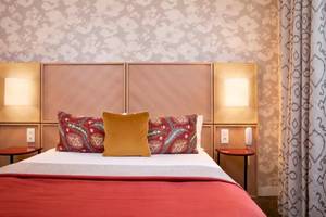 Hotelzimmer im Les Jardins d' Eiffel mit zwei Nachttischen, zwei Lampen und einem großen Bett.