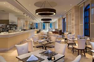 Innenansicht des Restaurants im Titanic Mardan Palace mit weißen Tischen und Stühlen.