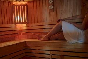Eine Person sitzt in einer Holzsauna im Novotel Paris Tour Eiffel Hotel.