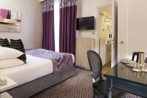 Hotelzimmer im Victor Hugo Paris Kléber mit Bett, Schreibtisch und Fernseher