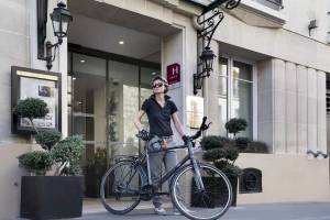Frau mit Fahrrad vor dem Hotel Victor Hugo Paris Kléber