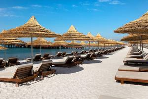 Strand mit Sonnenliegen und Sonnenhuten am Titanic Mardan Palace Hotel