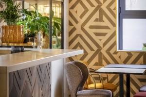 Innenansicht der Bar des Mercure Paris Bercy Bibliothèque Hotels mit Pflanzen, Stühlen und Tischen.