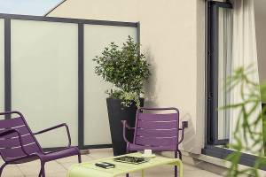Terrasse mit Möbeln und Pflanzen im Mercure Paris Bercy Bibliothèque Hotel.