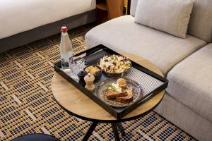 Frühstückstablett mit Toast, Salat und Getränk auf einem Tisch im Mercure Paris Bercy Bibliothèque Hotelzimmer