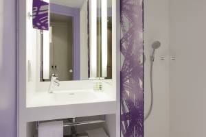 Badezimmer im Mercure Paris Centre Tour Eiffel Hotel mit violetten Wandmustern und einer Dusche.