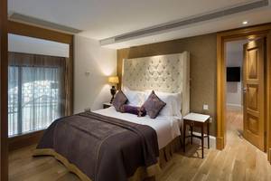 Ein elegantes Hotelzimmer im Titanic Mardan Palace mit einem großen Bett und bequemen Kissen.