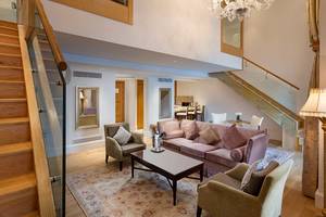 Ein modernes Hotel-Lobby-Design mit Sofa, Tisch, Kristallleuchter und Glastreppe.