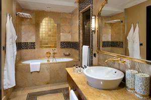Ein elegantes Badezimmer im Titanic Mardan Palace mit einer Badewanne, Waschbecken und Marmorboden.