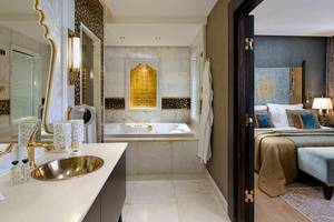 Ein Hotelzimmer mit einem Badezimmer, das eine Badewanne und einen Spiegel zeigt.