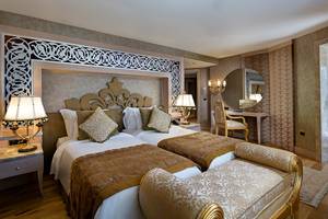 Zwei Betten im eleganten Hotelzimmer des Titanic Mardan Palace mit goldenen und weißen Bezügen.