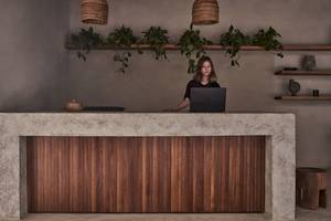 Rezeption im Casa Cook El Gouna Hotel mit einer Frau, die an einem Laptop arbeitet.