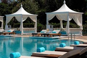 Pool-Lounge-Bereich im Titanic Mardan Palace Hotel mit weißen Zelten und Lounge-Liegen.