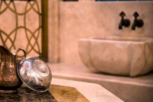 Bronzekrug und silberner Deckel im Badezimmer des Sunrise Queen Luxury Hotel