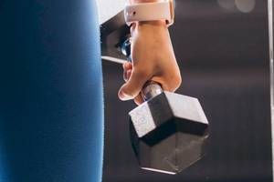 Person hebt eine Hantel im Fitnessstudio