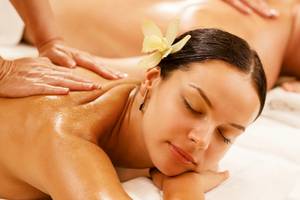 Massage im Sunrise Queen Luxury Hotel mit einer Frau, die auf einem weißen Handtuch liegt.