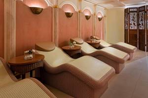 Massage-Lounge im Titanic Mardan Palace mit rosa Wänden und Liegen.