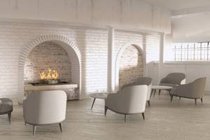 Loungebereich des Sunrise Queen Luxury Hotel mit weißen Sesseln und einem Kamin.