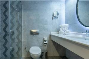 Das Badezimmer im Sunrise Queen Luxury Hotel mit einer Duschkabine, einem Waschbecken und einem Spiegel.