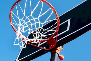 Basketballkorb mit Netz am Korbbrett, das an einem Pfosten befestigt ist.