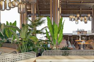 Innenbereich des Sunrise Queen Luxury Hotel mit Holzelementen, Pflanzen und Sitzbereichen.