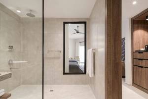 Badezimmer im Serry Beach Resort mit Regendusche, Spiegel und modernem Design.