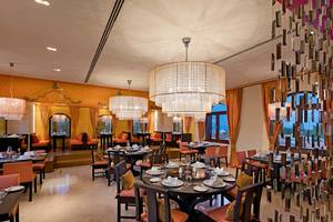 Innenansicht des Restaurants Titanic Mardan Palace mit runden Tischen und kristallenen Kronleuchtern.