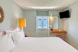 Schlafzimmer im Mykonos Theoxenia Boutique Hotel mit Bett, Lampen und Fenstern
