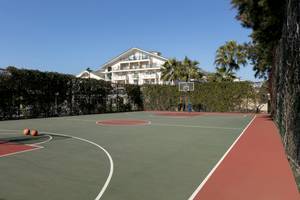 Basketballplatz vor dem Dobedan Exclusive Hotel & Spa Belek mit leerem Spielfeld und einer Villa im Hintergrund.