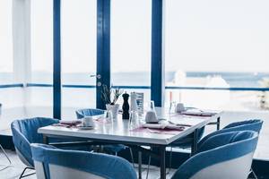 Ein Tisch im Restaurant des Mykonos Theoxenia Boutique Hotels mit Blick auf das Meer.