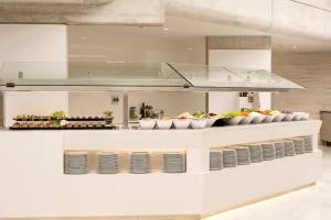 Buffet-Tisch im Hipotels Mediterraneo mit verschiedenen Speisen in weißen Schalen und Tellern.