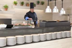 Koch im Restaurant des Hipotels Mediterraneo, der eine Speise zubereitet.