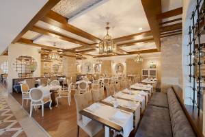 Innenansicht des Restaurants im Sentido Kamelya Fulya Hotel mit Tisch und Stühlen, Holzboden und Steinwänden.