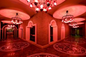 Roter Korridor im Sentido Kamelya Fulya Hotel mit roten Kronleuchtern und geometrischen Bodenmustern.