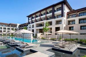 Außenpoolbereich des Lopesan Costa Bavaro Resort Spa & Casino mit Sonnenliegen und Sonnenschirmen.