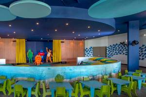 Innenbereich des Lopesan Costa Bavaro Resort Spa & Casino mit einem Kinderbereich und blauen Möbeln.