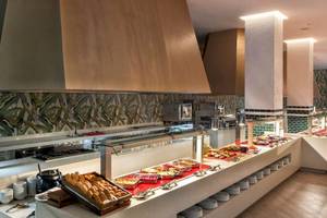 Innenansicht eines Buffet-Restaurants mit verschiedenen Speisen und modernen Dekorelementen.