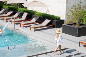 Schwimmbad im Lopesan Costa Bavaro Resort Spa & Casino mit Sonnenliegen, Sonnenschirmen und Gästen