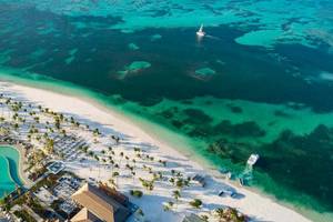 Luftaufnahme des Lopesan Costa Bavaro Resorts mit einem großen Pool, weißen Stränden und mehreren Booten im Wasser.