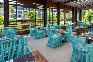 Außenbereich eines Gartenrestaurants mit blauen Stühlen und Tischen im Lopesan Costa Bavaro Resort Spa & Casino.