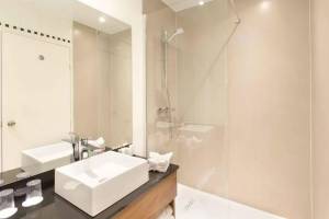 Badezimmer mit Dusche und Waschbecken im Crowne Plaza Paris République