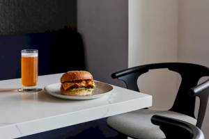 Ein Burger und ein Getränk stehen auf einem Tisch in einem Hotel.