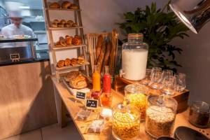 Frühstücksbuffet im Hotel Crowne Plaza Paris République mit Brot, Gebäck, Getränken und Cerealien.