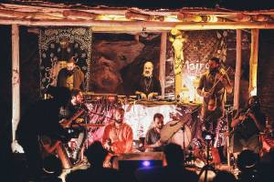 Mehrere Musiker spielen auf der Bühne im Club Marvy, mit Publikum im Vordergrund.