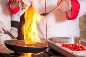 Koche mit Feuer im Topf und roten Pfeffer auf einem Teller im Victory Hotel & Spa Istanbul