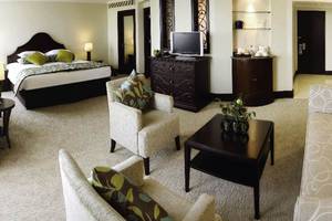 Suite-Zimmer im JA Beach Hotel mit Doppelbett, Wohnzimmer und Nachttisch