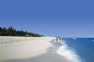 Paar am Strand vor dem JA Beach Hotel