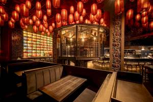 Innenbereich des Five Luxe JBR Restaurants mit roten Laternen an der Decke und Holztischen.