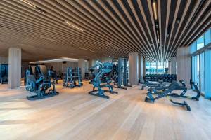 Fitnesscenter im Five Luxe JBR Hotel mit modernen Geräten und Holzboden.