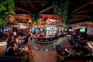 Innenbereich der Bar im FIVE LUXE JBR Hotel mit Gästen, die an Tischen sitzen und trinken.